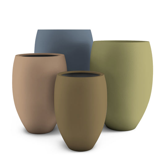 Del Mar GFRC planters in various sizes, shown indoors with lush greenery, highlighting their smooth, curved form and elegant matte texture