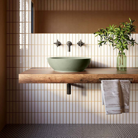 Monterrey Concrete Sink in sage green shown in a modern bathroom setting with vertical tile, a floating wood vanity, and wall-mounted matte black faucet.