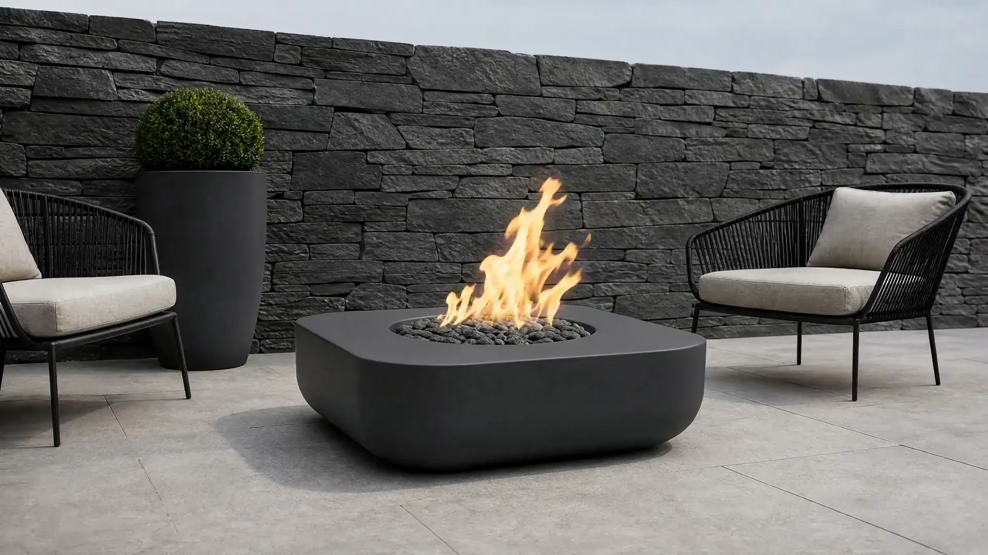 Montecito fire pit burning on a terrace against a stacked stone wall